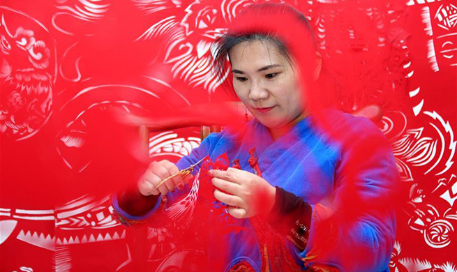 Folk artist makes pig-themed paper cutting artwork to greet Year of Pig in China's Shandong